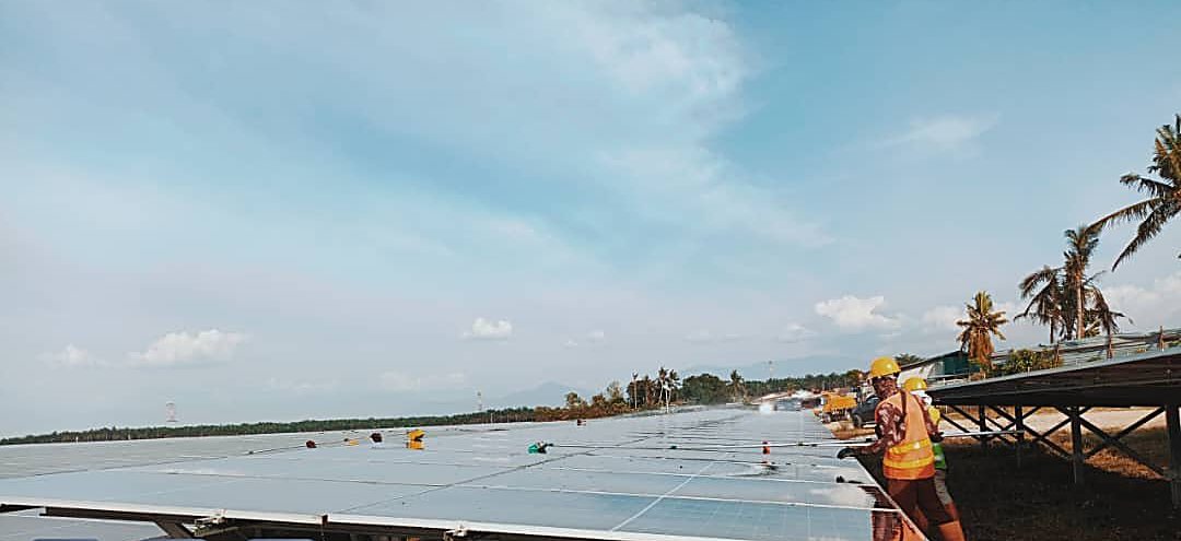 Panel cleaning crew in full PPE at solar farm